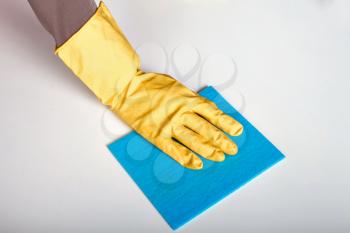 Female person hand in rubber gloves holding claening rag. Housekeeping concept