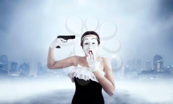 Mime female artist performing with gun. Comedian performer. Pantomime theater actress with weapon. April fools day concept