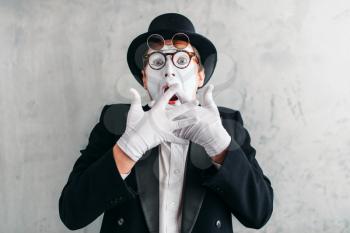 Funny mime actor with makeup mask. Pantomime in suit, gloves and hat. April fools day concept