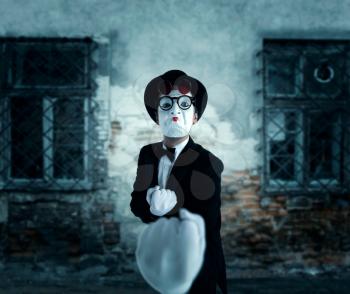Pantomime actor in glasses shows boxer. Mime in suit, gloves and hat. April fools day concept