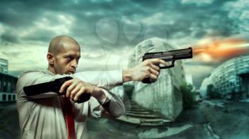 Serious hired killer in red tie shoot a pistols with two hands, night urban landscape on background. Contract assassin shooting action wallpaper or poster concept