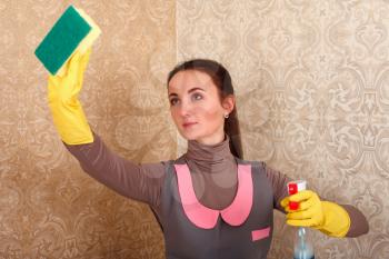 Cleaning servisce lady in rubber gloves work with spray. Housekeeping concept