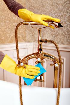 Female person hands in rubber gloves cleans sanitary equipment. Housekeeping concept