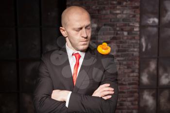 Contract killer in suit and red tie shows his fears and secrets. Special agent holds little toy duck in hand. Hired murderer wallpaper or background
