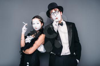 Pantomime actors posing with cigar and cigarette. Comedy artist and actress performing. Mime theater performers 