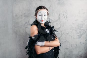 Pantomime actress with white makeup mask posing in studio. Comedy female artist performing
