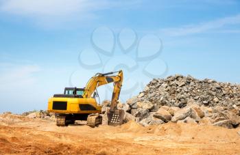 Excavation mashine works in a quarry. Yellow earth mover digging sand