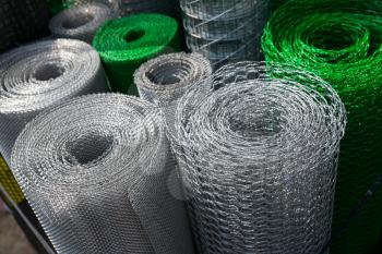 Barbed wire and mesh netting rolls. Danger barrier for security and protection 