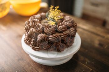 Fresh cake with chocolate biscuit cream, culinary masterpiece, closeup view. Sweet dessert on wooden background