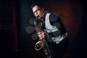 Male saxophonist playing classical jazz melody on sax. Jazz-man concept
