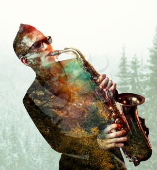 Male saxophonist playing on saxophone, forest texture and background, double exposure