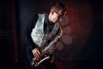 Professional male saxophonist playing jazz musical melody on saxophone