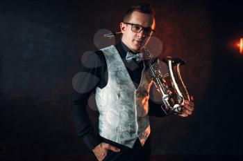 Portrait of male saxophonist with saxophone, jazz man with sax. Classical brass band instrument