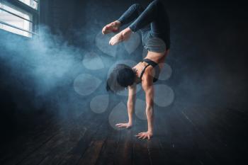 Body flexibility, contemp style dancer in dance class. Female performer poses in gymnastic studio