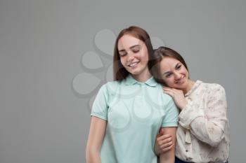 Two women hugs together, studio photo shoot. Female friendship