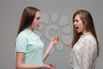 Two young women screams at each other. Women quarrel
