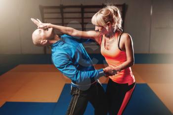 Women self defense technique, workout with personal instructor in gym, martial art