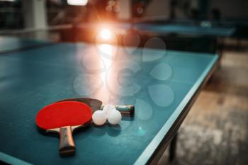 Ping pong table with rackets and balls in a sport hall, game equipment. Indoor tennis club