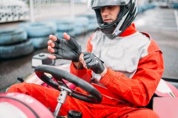 Go-kart driver in helmet on karting speed track. Carting race