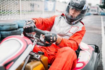 Karting race, go cart driver in helmet on carting speed track. Go-kart racer