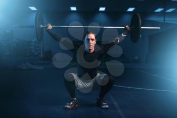 Strength athlete on training, workout with barbell in gym. Active sport exercises in fitness club
