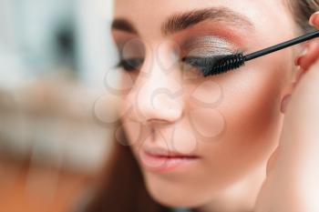 Make up artist work with woman eyes, beauty studio on background. Cosmetic salon