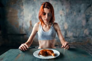 Unhappy skinny woman against plate with food, absence of appetite. Fat or calories burning concept. Weight loss, anorexia