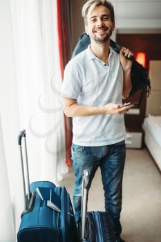Young man with suitcases prepares for a journey. Fees on vacation concept. Luggage preparation. Travelling or tourism