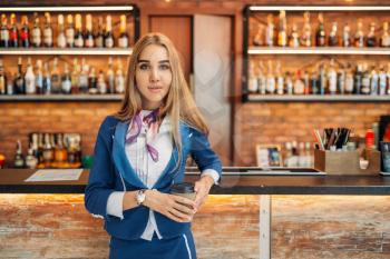 Stewardess drinks coffee at the bar counter in airport cafe. Air hostess with baggage, flight attendant with hand luggage, aviatransportations job