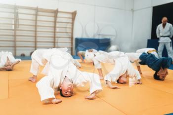 Children judo, kids in kimono practice martial art in gym. Little boys and girls in uniform on sport training