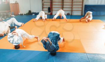 Children judo, kids in kimono practice martial art in hall. Little boys and girls in uniform on sport training