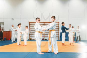 Kid judo, childrens training martial art in hall. Little boys in uniform, young fighters