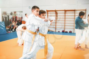 Kid judo, childrens training martial art in hall. Little boys in uniform, young fighters