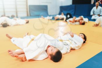 Kid judo, fight training, martial art, self-defense. Little boys in uniform in sport gym, young fighters