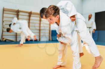 Kid judo, young fighters on training, self-defense. Little boys in kimono practice martial art