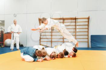 Little boys in kimono practice martial art. Kid judo, young fighters on sport training in gym
