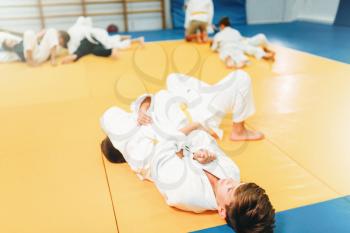 Boys in uniform, kid judo training. Young fighters in gym, martial art for defense
