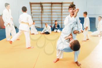 Boys in kimono fights, kid judo training. Young fighters in gym, martial art for defense