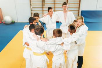 Boys in kimono on kid judo training indoor. Young fighters in gym, martial art for defense