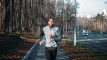 Male runner in sportswear on training outdoor. Jogger on morning workout. Athletic man running marathon
