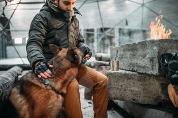 Stalker, post-apocalypse soldier feeding a dog. Post apocalyptic lifestyle on ruins, doomsday, judgment day 