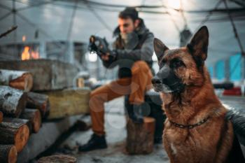 Stalker measures the radiation level in nuclear explosion zone against his dog. Post apocalyptic lifestyle on ruins, doomsday, judgment day 