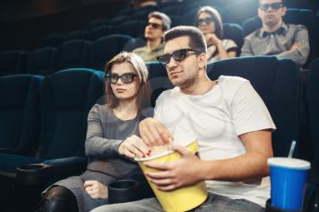 Smiling couple watching comedy movie in cinema. Showtime, entertainment industry