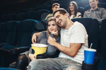 Smiling couple watching comedy movie in cinema. Showtime, entertainment industry