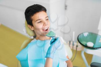 Female dentist makes teeth impression, boy in dental chair, pediatric dentistry, children stomatology