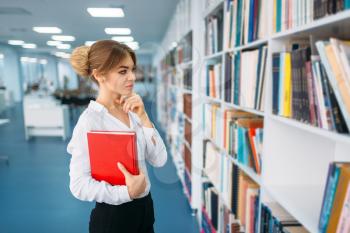 Young woman looking book at the shelf in library. Female person in reading room