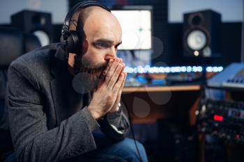 Sound producer listens composition in recording studio. Professional audio and music mixing technology