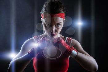 Female boxer in red boxing bandages and sportswear, front view. Fighting sport concept