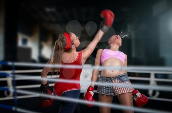 Two female kickboxers fights on the ring, low kick. Fighting sport and martial art concept