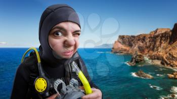 Female diver in wetsuit and diving gear, ocean on background. Frogman  on the beach, underwater sport